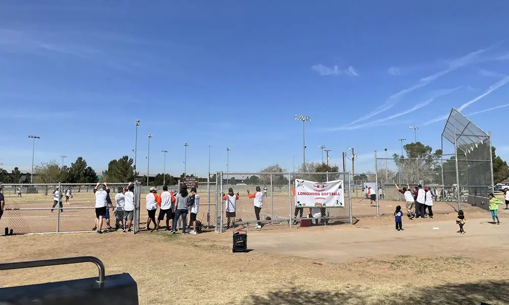 A group of people standing around in the dirt.