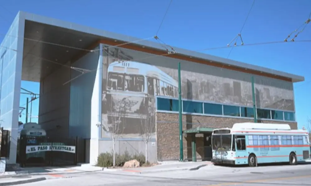 A bus parked in front of a building with a large mural on the side.