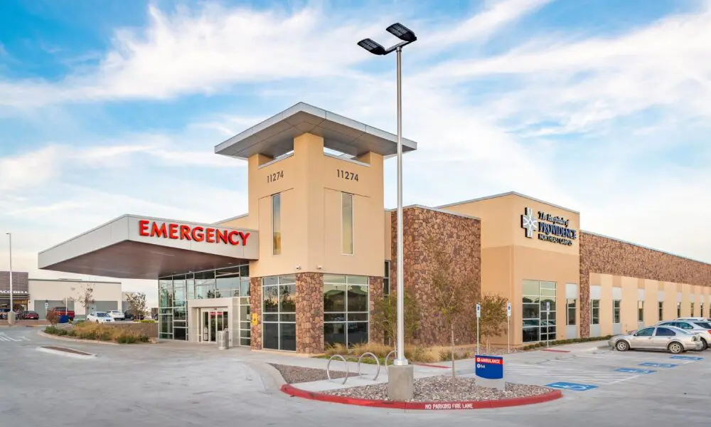 A hospital with a large building and a street light.