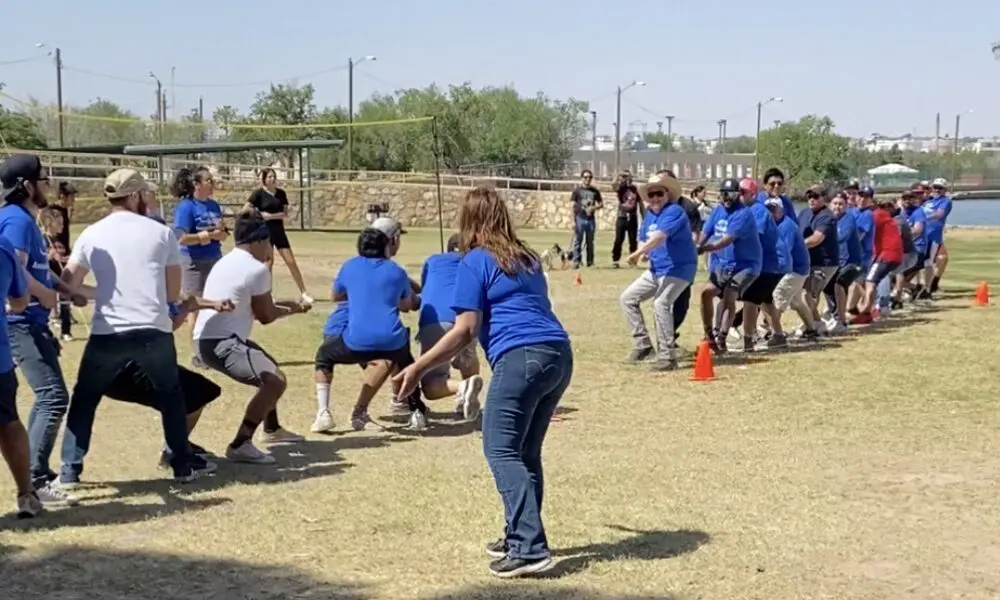 A group of people playing frisbee in the dirt.