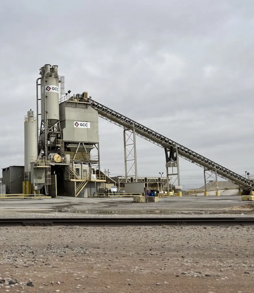 A cement plant with a person standing on the side of it.